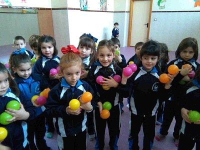 Niños con bolas de colores de la mano realizando una actividad dentro del aula de psicomotricidad